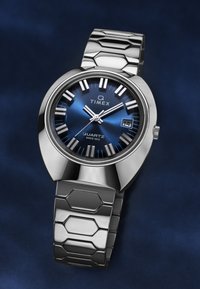 Ezüst rozsdamentes acél kvarcóra kék napfény hatású számlappal, ezüst színű órajelzőkkel és hatszögletű láncszegélyes szíjjal. Dátum kijelző 3 óránál.