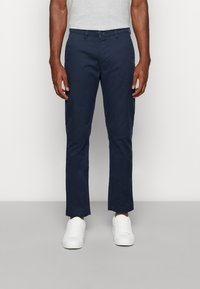 Chino blu navy realizzati in cotone, con design a gamba dritta, chiusura con bottone e due tasche frontali con una texture liscia.