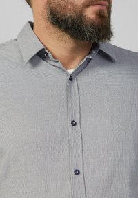Korte mouwen button-up shirt in lichtgrijs met een gestructureerd patroon. Voorzien van een kraag en donkere knopen. Stof lijkt ademend te zijn.