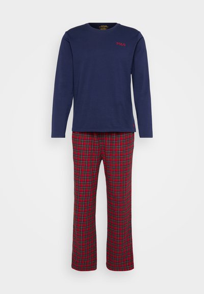 Camisa de manga longa azul-marinho com bordado em vermelho "POLO", combinada com calças xadrez em vermelho e preto com um corte reto. Material em mistura de algodão.