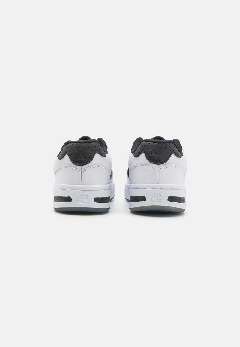 Zapatillas blancas con acentos negros, parte superior de cuero suave, detalles perforados en el talón, cuello acolchado y suela de goma texturizada.