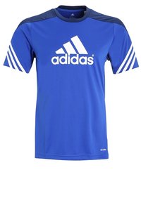 Sininen Adidas-paita valkoisella logolla, lyhyet hihat ja tummansiniset yksityiskohdat hartioissa. Valmistettu hengittävästä materiaalista, jossa on kolme raitaa hihoissa.