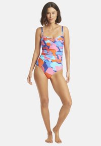 Maillot de bain une pièce avec un motif abstrait multicolore. Il dispose de bretelles ajustables et de côtés froncés. Le tissu est extensible et lisse.