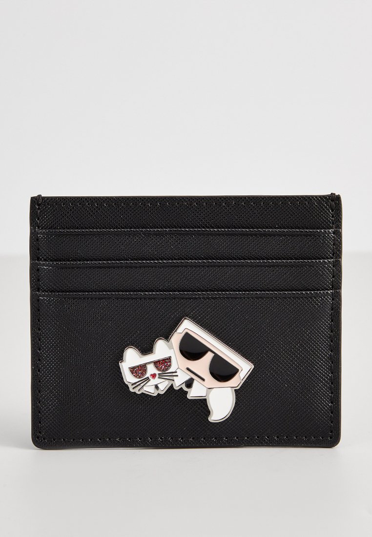 Portafoglio nero realizzato in materiale testurizzato con quattro scomparti. Presenta un design a pin di un gatto e un personaggio dei cartoni animati con occhiali da sole.