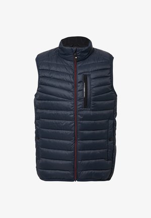 Marineblauwe gewatteerde vest met hoge kraag, voor rits en een ritszak op de borst. Kenmerkt zich door een contrasterende rode rits en platte stiksels.