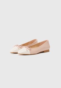 Ballet flats with a glossy light pink body, white cap toe, and small bow detail on the front; flat light brown sole.