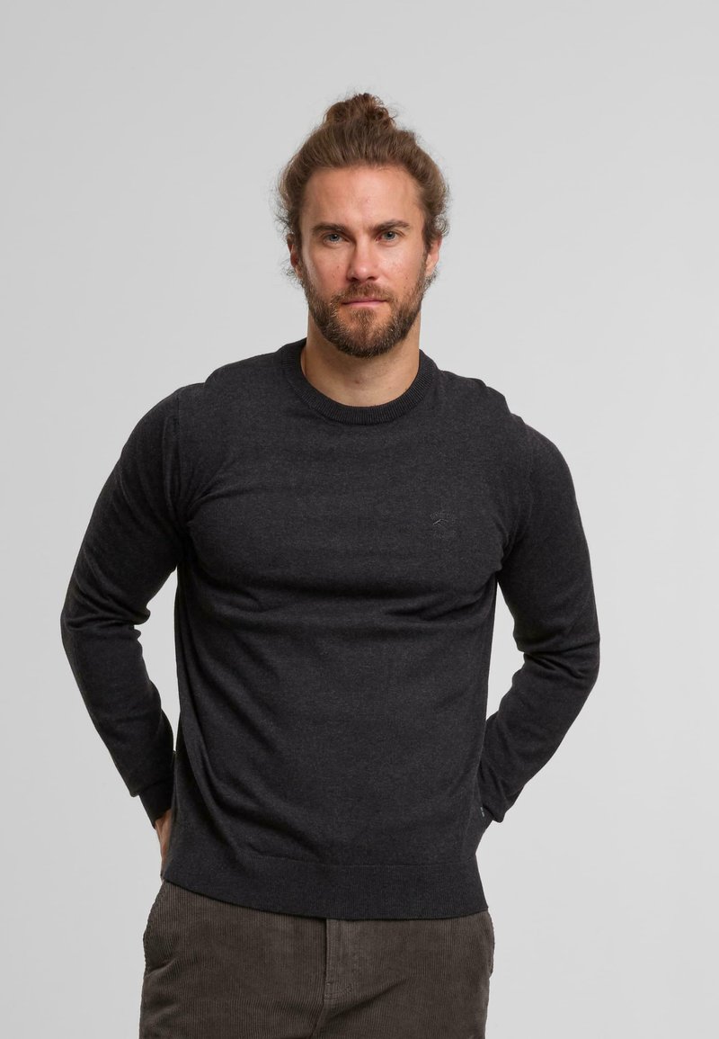 Pull gris foncé avec des manches longues, col et ourlet côtelés, fabriqué à partir d'un matériau doux. Design simple, peu de détails sur la poitrine.