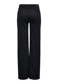 Jean noir taille haute à jambes larges, avec poches arrière, passants de ceinture et un patch logo sur la ceinture, vu de dos.