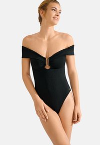 Maillot de bain noir en une pièce avec des manches dénudées, un détail en forme de clé à la poitrine et un accent doré au centre. Texture lisse et brillante.