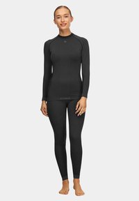 Czarna, długorękawowa bluzka i legginsy z elastycznego materiału, z dopasowanym krojem i subtelnym logo na pasku.