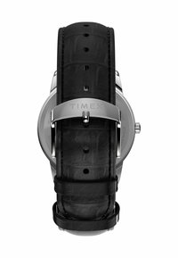 Montre Timex avec un boîtier en acier inoxydable, un bracelet en cuir noir avec un motif crocodile, et une boucle en métal argenté ornée du nom de la marque gravé.