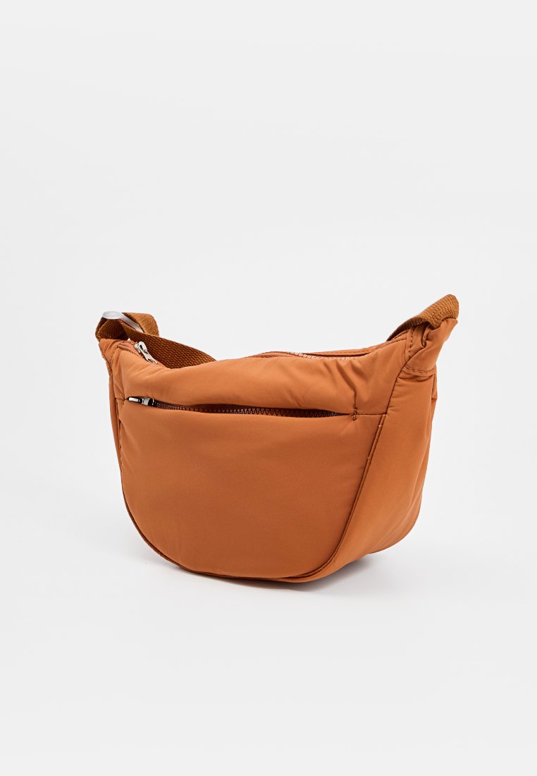Sac bandoulière en nylon marron avec une forme arrondie, poche zippée et bandoulière texturée. Un rembourrage doux donne une apparence lisse et légère.