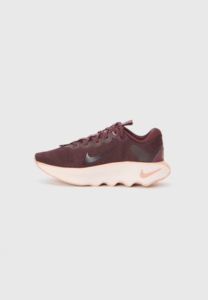 Botte de sport bordeaux avec une tige en tissu texturé, des accents noirs et une semelle blanche rembourrée présentant un design ondulé et des détails de logo.
