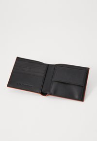 Black leather wallet with orange accent along the edge. Features multiple card slots and a side pocket. Embossed logo on interior.