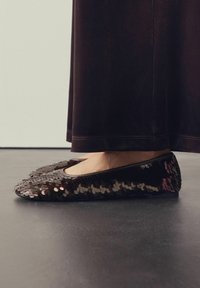 Balerini negri din paiete, cu vârf rotund, având mici paiete circulare în nuanțe variate de marron și o talpă netedă, rotundă.