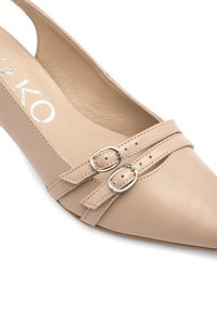 Décolleté beige con punta affilata, parte superiore in pelle, due cinturini decorativi con fibbie argentate e soletta texturizzata.