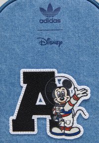 Toppa in denim con una grande "A" nera e Topolino ricamato in tuta spaziale, messo in risalto con accenti rossi e blu.