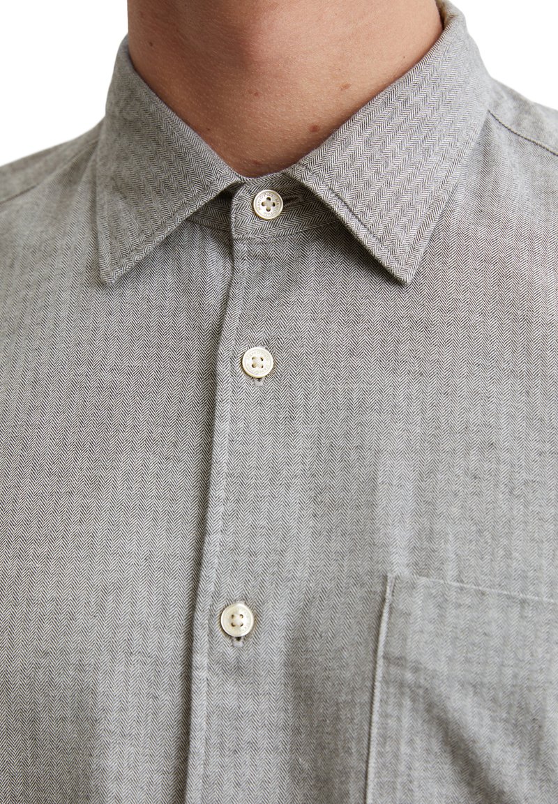 Grau gemusterte Hemd im Fischgrätenmuster mit spitzem Kragen, weißen Knöpfen und einer Brusttasche, aus leichtem Stoff gefertigt.
