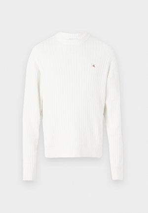 Sweater branco canelado com mangas longas, decote redondo e um pequeno logo vermelho no peito. Textura suave e design ajustado.