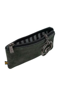 Bolsa de ante verde con cremallera, forro interior a rayas negras, anilla para llaves y detalles de herrajes sutiles. Diseño compacto y rectangular.