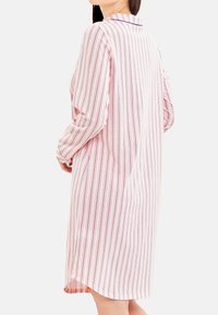 Abito camicia lungo a righe in tessuto leggero. Presenta righe verticali rosa e blu navy, colletto con bottoni e maniche lunghe. Fessure laterali all'orlo.