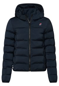 Mørkeblå pufferjakke med hætte, frontlynlås, horisontal quiltning og lille rød og hvidt logo på brystet.