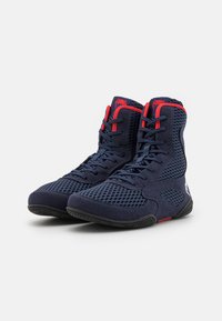 High-top athletic shoes in dark navy with red accents, featuring a breathable mesh design and textured synthetic material. Rubber sole for grip.