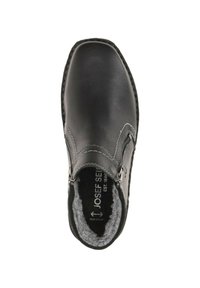 Chaussure noire en cuir à enfiler avec doublure en fourrure, couture décorative et accent de fermeture éclair en argent. Semelle plate et design à bout arrondi.