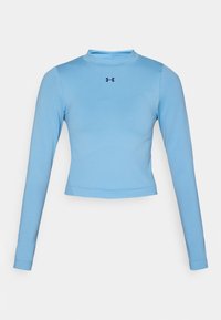 Lys blå langermet crop top laget av glatt stoff, med høy hals og en liten logo i marineblått på brystet.