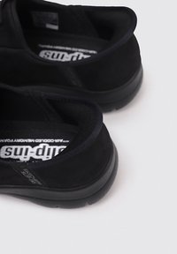 Chaussures noires en daim à enfiler avec une semelle en caoutchouc épaisse et un col rembourré, dotées de semelles intérieures en "Air-Cooled Memory Foam" et d'accents texturés.