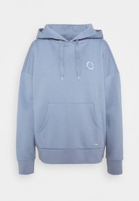 Ljusblå hoodie i mjukt tyg, med en framficka, snörning i huvan och en liten cirkulär logotyp på bröstet.