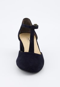 Zapato de tacón alto de ante en color azul marino con diseño de tiras en T, punta afilada y acabado suave, que presenta una pequeña hebilla para un ajuste seguro.