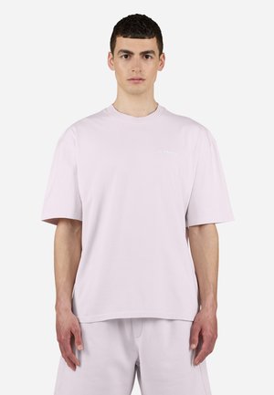 Light pink oversized t-shirt with short sleeves, crew neck, and a subtle logo on the chest. Soft cotton fabric and relaxed fit.
