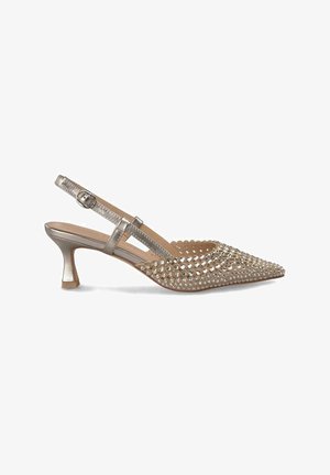 Złote sandały na obcasie typu slingback z ostro zakończonym noskiem, ozdobione ćwiekami, z obcasem średniej wysokości i cienkim regulowanym paskiem wokół kostki.