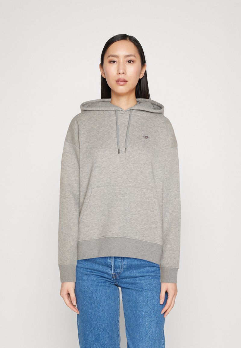 Hall halliga sweatshirti, millel on esikott, nöörid ja soonikkoes. Valmistatud pehmest kangast, millel on minimaalne tikandlogoga rinnal.
