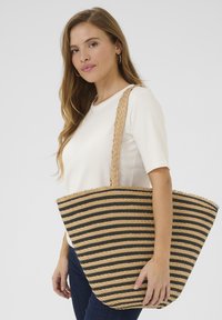 Grande borsa tote realizzata in fibra naturale intrecciata con strisce orizzontali nere e beige. Presenta un'ampia apertura e manici spessi intrecciati.