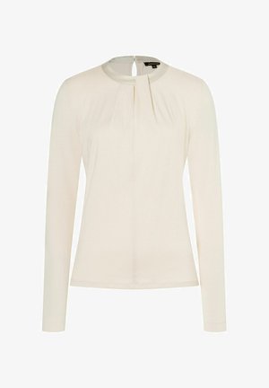 Long-sleeve, light beige top with round neckline and back keyhole detail. Features subtle pleats at the front for texture and design.