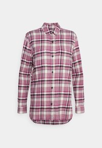 Rutigt flanellskjorta i nyanser av rosa, vitt och svart. Har knäppning fram, spetsig krage och lång ärm med manschetter.