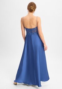 Abito lungo in satin blu con schiena in pizzo trasparente e spalline sottili regolabili, caratterizzato da una gonna fluida e una leggera lucentezza.