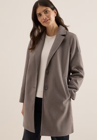 Manteau en mélange de laine gris au design ajusté, avec de grands revers, deux boutons et des poches latérales. Présente un léger logo brodé sur la manche.