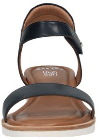 Černé kožené sandály s dvěma širokými pásky, polstrovanou hnědou stélkou a bílou gumovou podrážkou. Jednoduchý design s nastavitelným přezkovým detailem.