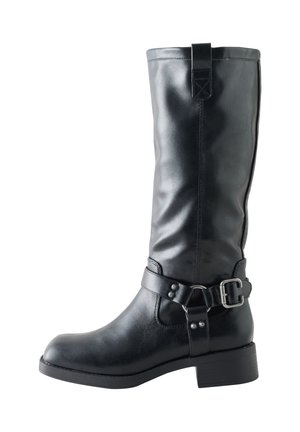 Black mid-calf leather boot with rounded toe, low block heel, and decorative side strap with silver buckle and rivets.