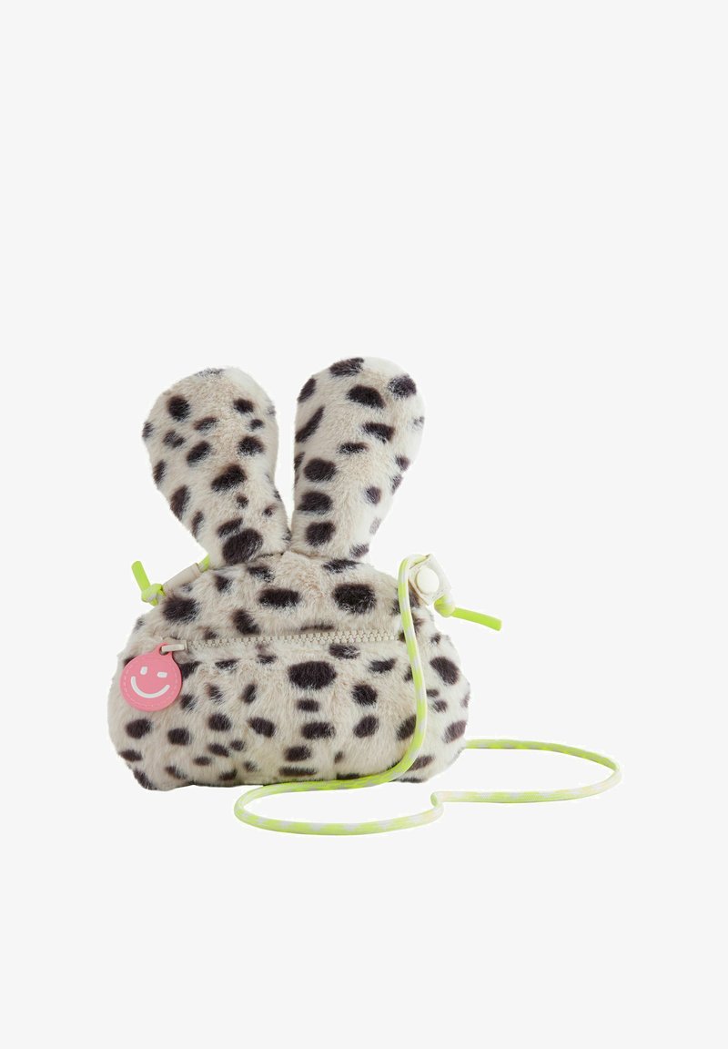 Valkoinen tekoturkispussi mustilla pilkuilla; siinä on pupun korvat, vetoketju, vaaleanpunainen hymymerkki ja neonvihreä hihna.