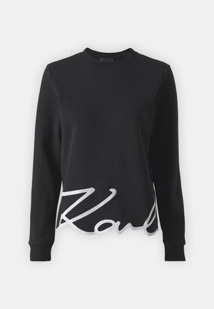 Schwarzer Sweatshirt aus Baumwolle mit langen Ärmeln, Rundhalsausschnitt und einem weißen gestickten 'K'-Akzent an der unteren Vorderseite.