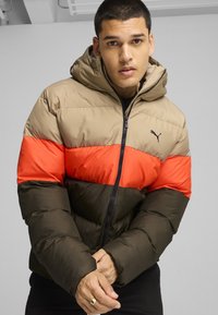 Jacketas su paminkštinimu ir kapišonu, su šviesiai ruda, oranžine ir tamsiai žaliais segmentais, užtrauktuku užsegamas, juodas logotipas kairėje pusėje. Lygus paviršius.