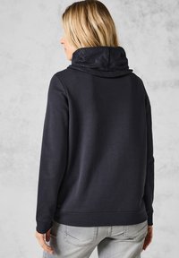 Sudadera marina con capucha negra texturizada, con un corte relajado, puños acanalados y dobladillo. Fabricada con un material suave y sin estampados visibles.