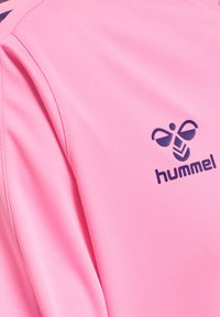 Roze sportkledingstuk met donkerblauw hummel-logo met gestileerde hommel en chevron-ontwerp op het bovenste borstgebied.