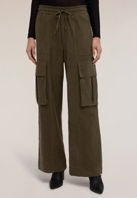 Pantalones cargo verde oliva con cintura elástica, cordón, bolsillos laterales y diseño de pierna ancha. La tela texturizada ofrece un acabado suave.