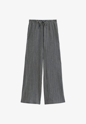 Spodnie typu wide-leg z elastycznym pasem i sznurkiem do regulacji, z naprzemiennymi czarnymi i białymi pionowymi paskami, położone na białym tle.