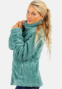 Pullover in pile verde acqua con colletto alto, tasca laterale con zip e polsini a costine, caratterizzato da una superficie morbida e testurizzata e da un fit rilassato.